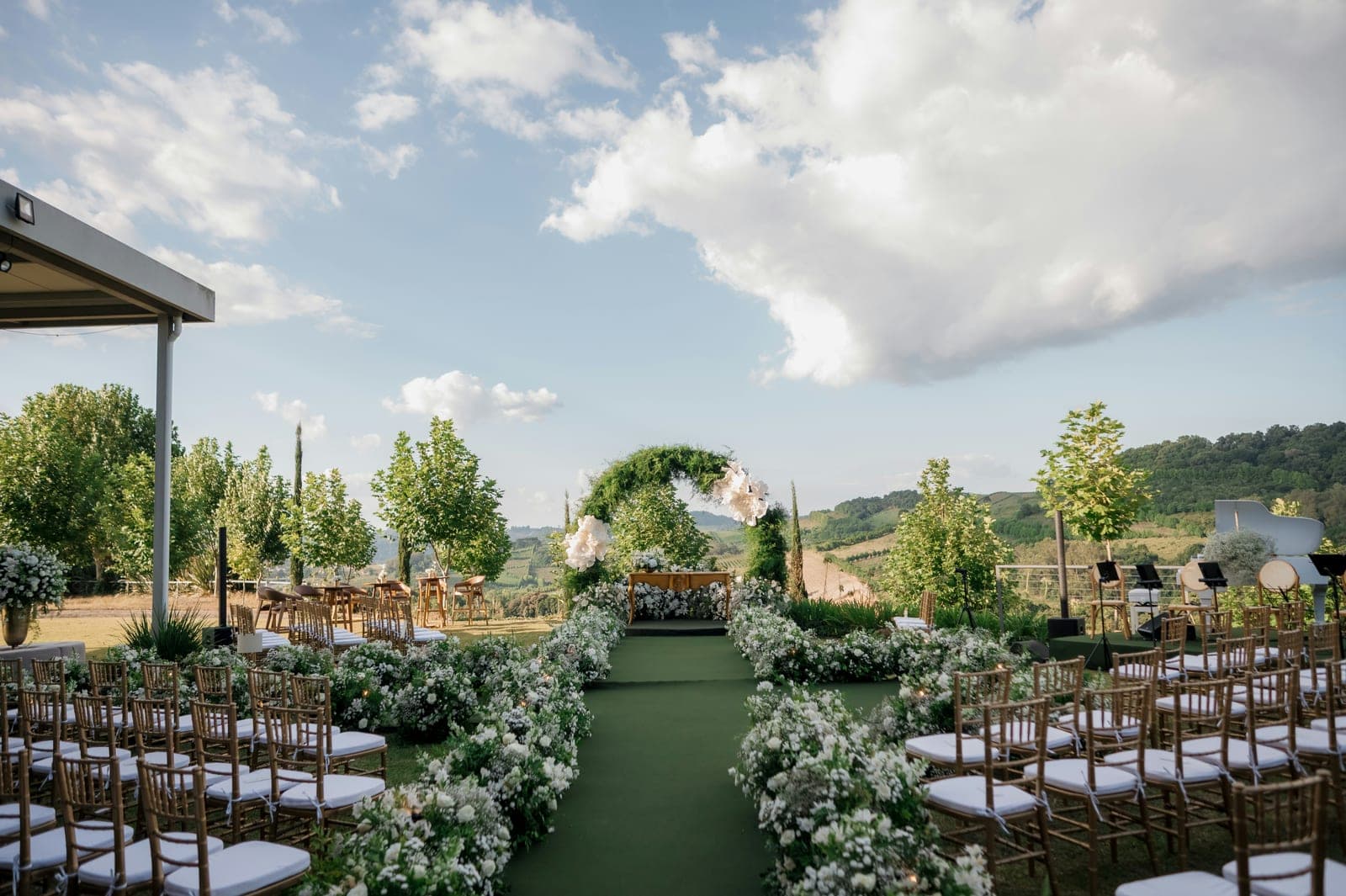 An outdoor wedding ceremony set up with an aisle and floral arch